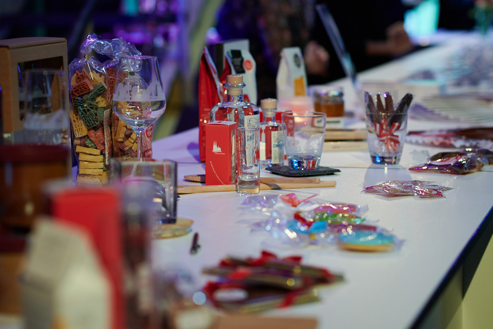 Gastgeschenke, wie Dom-Pasta, Kugelschreiber und Parfüm stehen auf einem Tisch