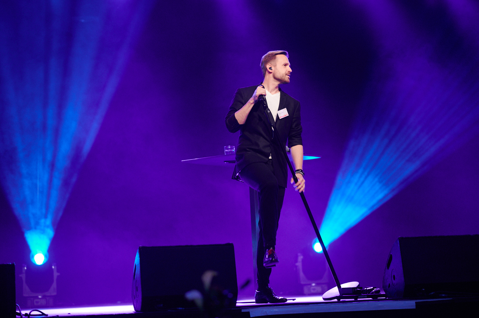 Ein Sänger singt auf der Bühne mit blauer Beleuchtung