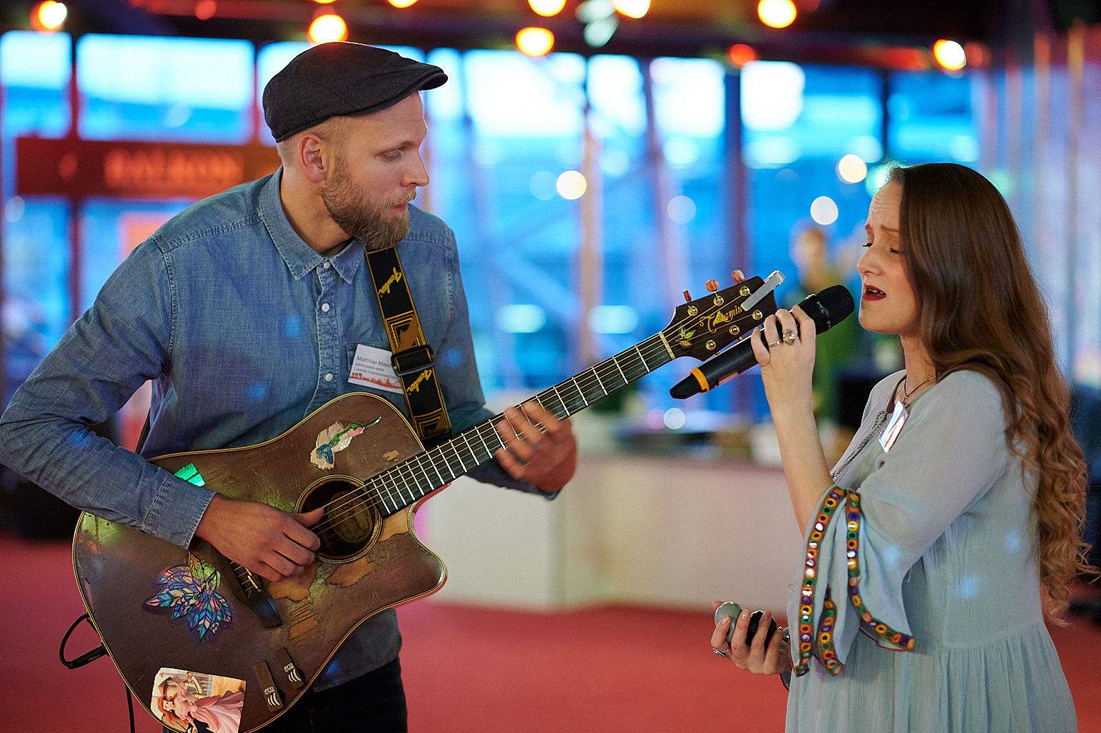 Gitarrist und Sängerin machen zusammen Musik auf einer Veranstaltung