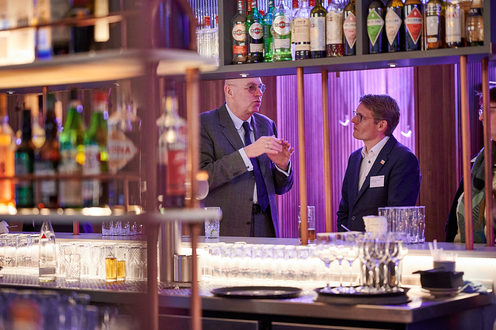 Zwei Männer unterhalten sich an der Bar.