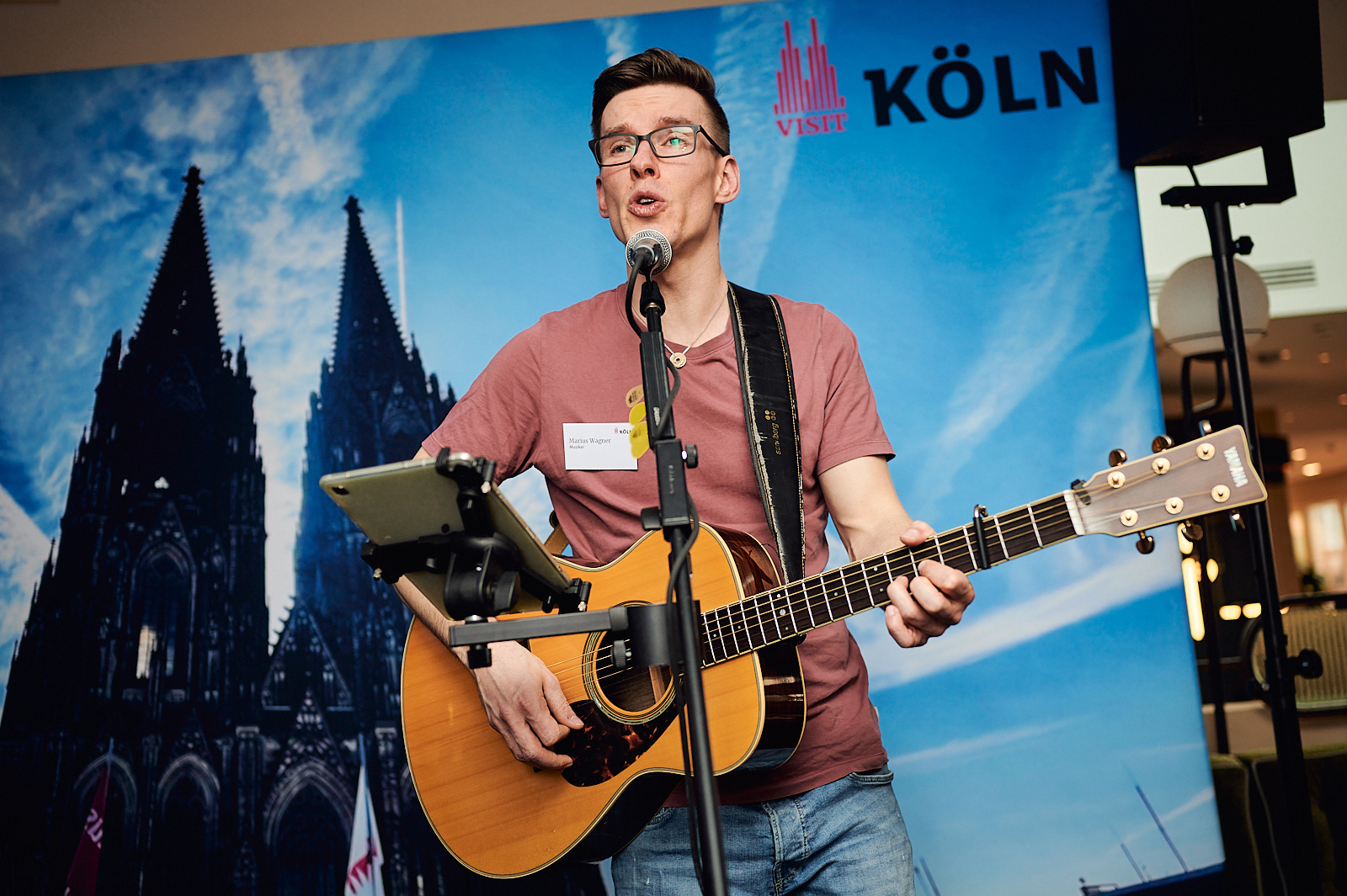 Musiker singt und spielt Gitarre auf der Bühne