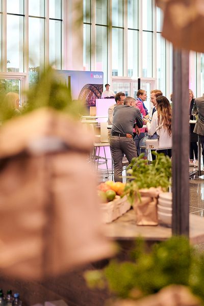 Kamera fotografiert zwischen den Elementen der Kochstation die Gäste der Veranstaltung