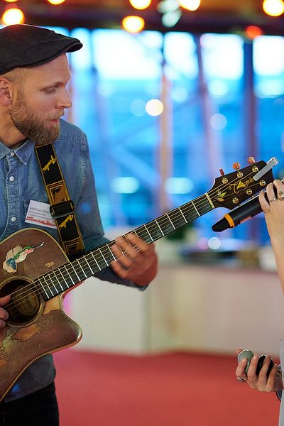 Gitarrist und Sängerin machen zusammen Musik auf einer Veranstaltung