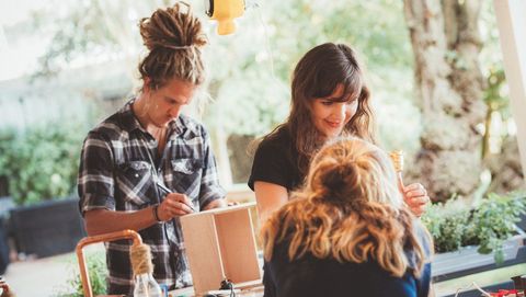 Ein Mann und zwei Frauen nehmen an einem handwerklichen Workshop teil
