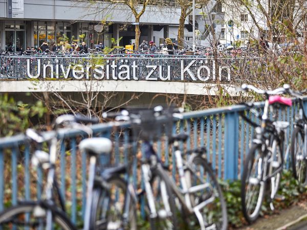 Schriftzug Universität zu Köln mit Fahrradständern im Hintergrund