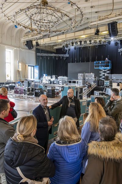 Gruppe besichtigt den Gürzenich Köln, im Hintergrund wird eine Bühne und Technik aufgebaut