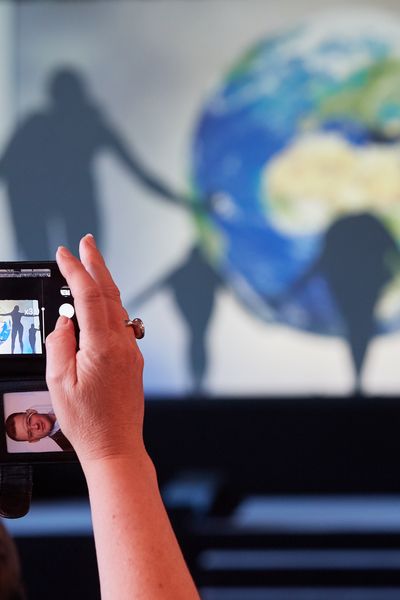 Frau fotografiert Schattentheater durch ein Handy