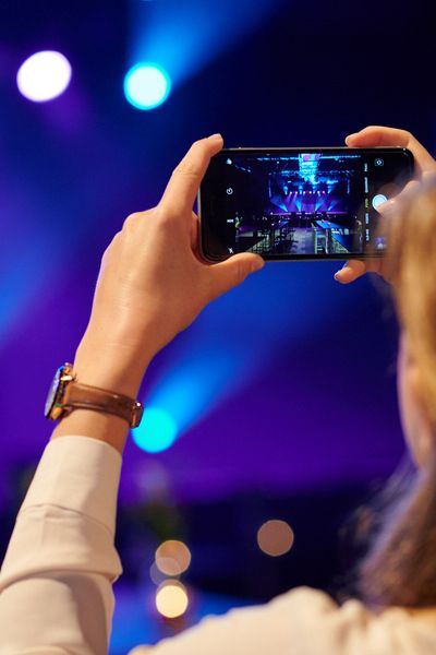 Eine Frau fotografiert die leere Bühne mit ihrem Handy