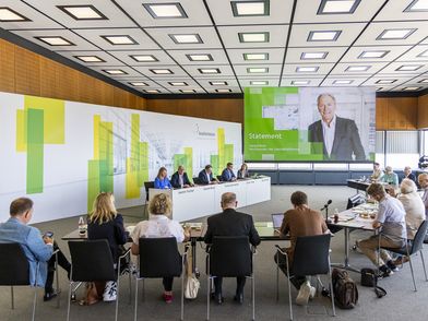 Eine Gruppe von Menschen sitzt in einem Konferenzraum in UForm zur Finanzpressekonferenz der Koelnmesse