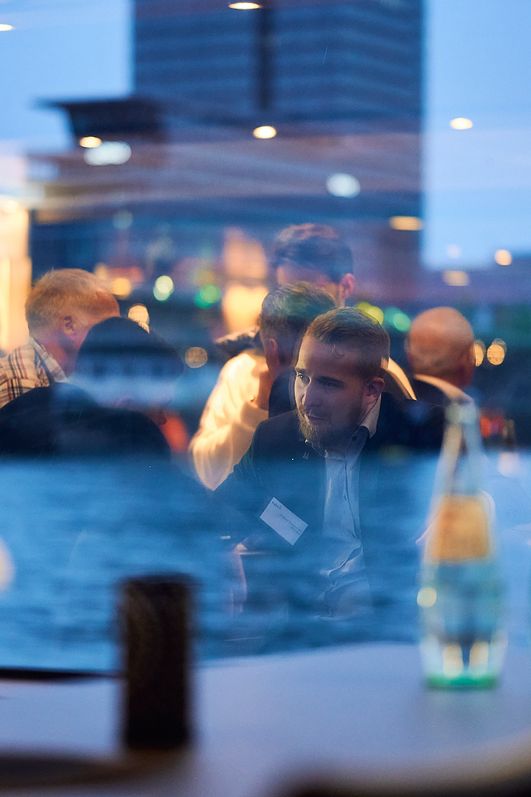 Blick aus dem Fenster der KD auf den Rhein: In der Scheibe spiegeln sich ins Gespräch vertiefte Personen