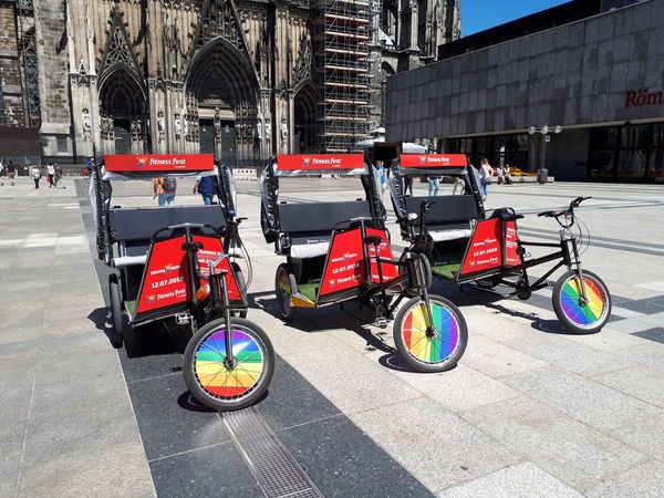 Drei rote Rikschas stehen vor dem Dom