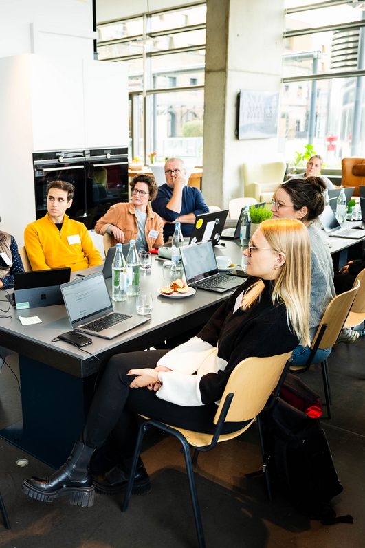 Workshop Teilnehmer hören der Moderatorin aufmerksam zu