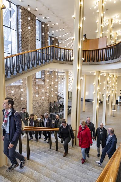 Gruppe steigt die Treppe des prunkvollen Gürzenich hoch. Von oben fotografiert.