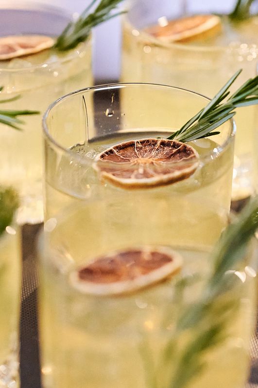 Gläser mit gelben Cocktails, getrockneter Zitrone und Rosmarinstange
