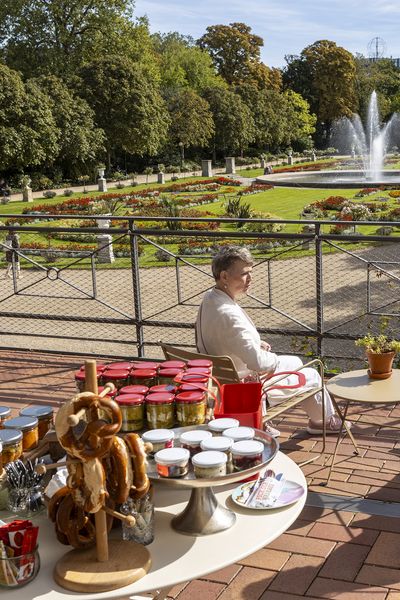 Zwei Frauen sitzen mit dem Rücken zur Kamera auf Stühlen und schauen in den Botanischen Garten