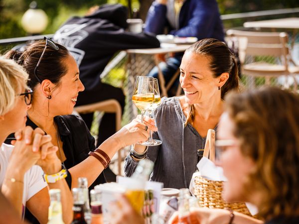 Firmenpicknick in der Dank Augusta: Eine Runde Frauen stößt mit Sekt an.