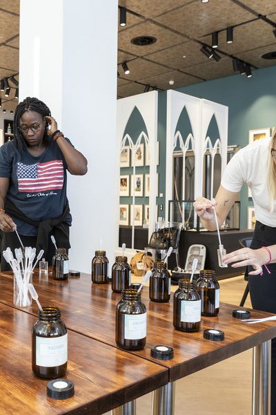 Parfum Workshop: 3 Frauen stehen um einen Tisch und holen Duftöle mit Pipetten aus Flaschen