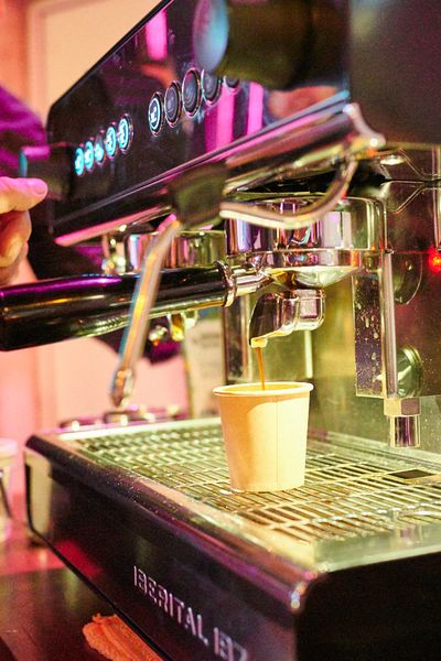 Nachaufnahme: Kaffee läuft aus der Maschine in den Becher