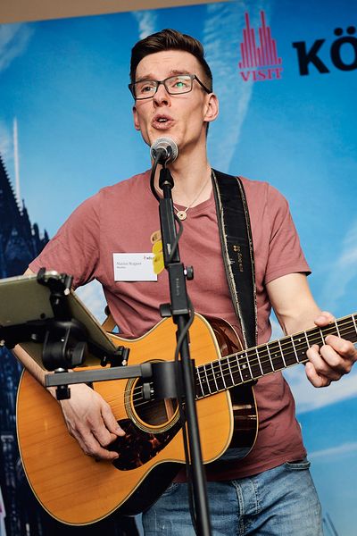 Musiker singt und spielt Gitarre auf der Bühne