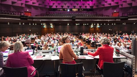 Voller Kongresssaal mit vier Moderatorinnen auf der Bühne