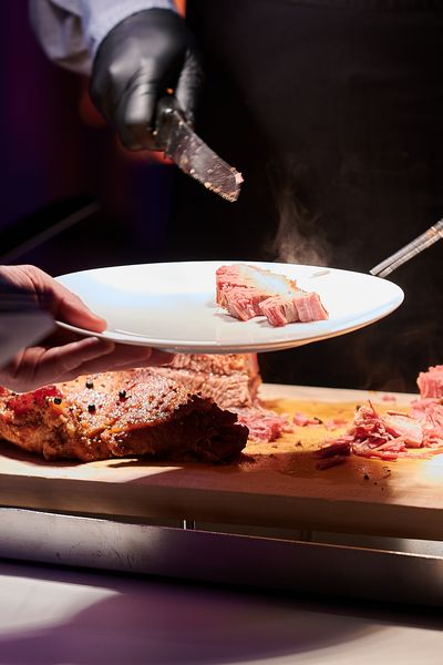 Veranstaltungscatering: Zartes Fleisch wird auf einem Teller zubereitet