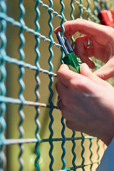 Liebesschloss wird an ein Gitter gehängt