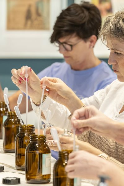 Parfum Workshop: 4 Frauen stehen in einer Reihe und holen Duftöl mit Pipetten aus Flaschen