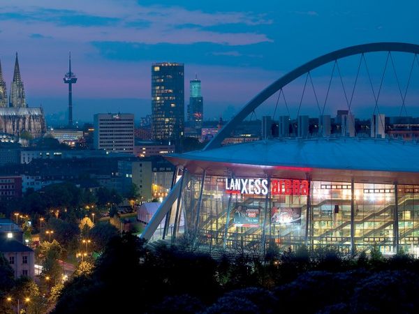 Lanxess arena mit dem Kölner Dom im Hintergrund bei Nacht