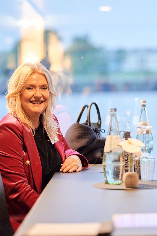 Eine Frau und ein Mann sitzen an einem Tisch und lächeln in die Kamera
