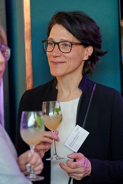 Gäste unterhalten sich beim Networking mit Getränken in den Händen