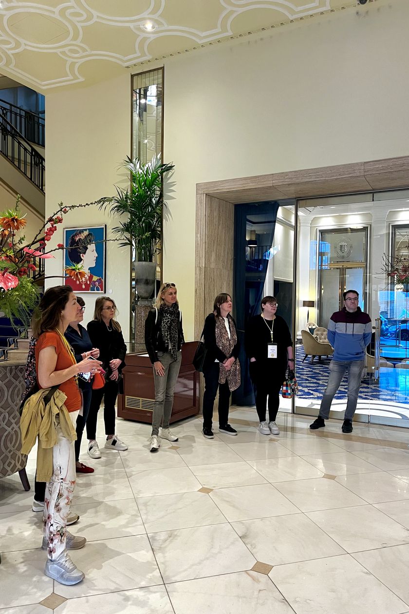 Gruppe steht im Halbkreis im Foyer des Excelsior Hotel Ernst