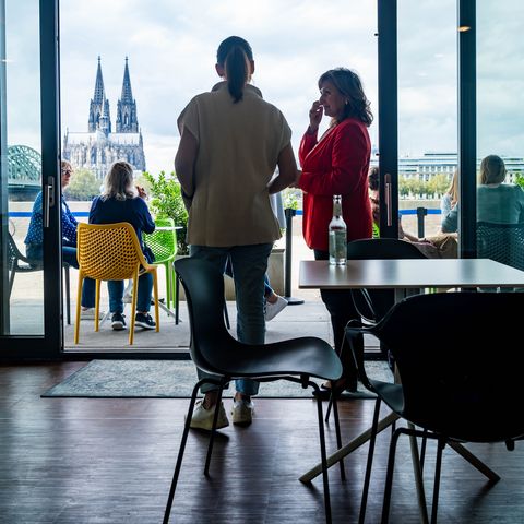 Personen stehen am Panoramafenster mit Blick auf den Dom