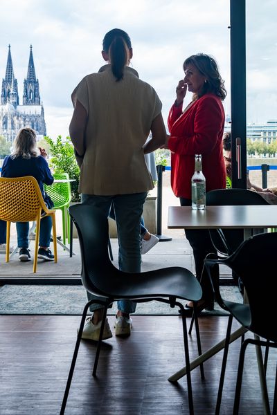 Personen stehen am Panoramafenster mit Blick auf den Dom