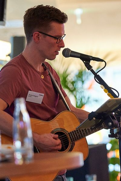 Musiker singt und spielt Gitarre beim Networking