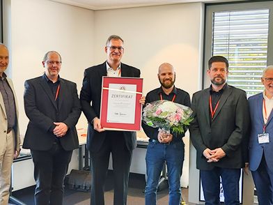 Das Team von Kuchem Konferenz Technik hält ihre Auszeichnung in den Händen