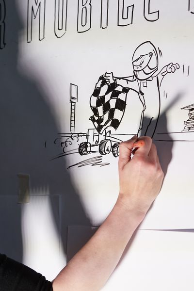 Eine Frau zeichnet Sketches an der Wand