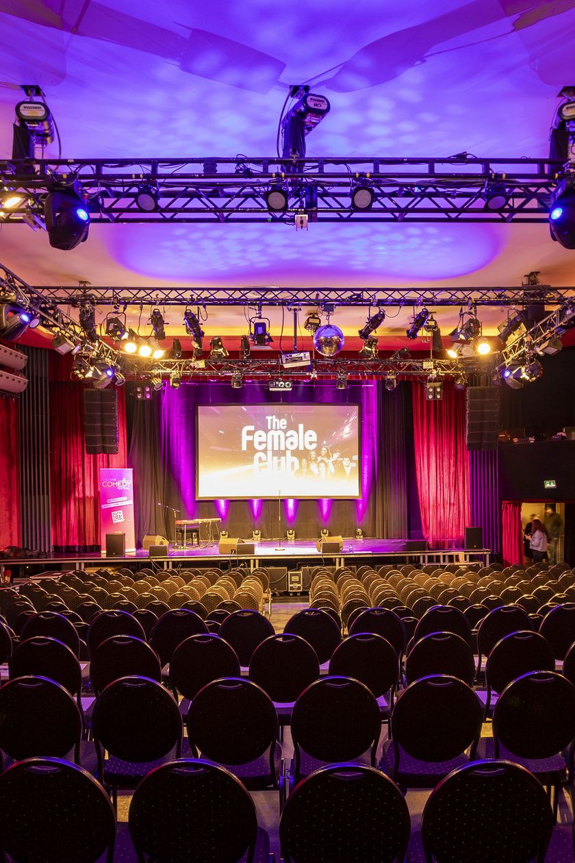 Gloria Theater mit rot-lila Beleuchtung von hinten auf die Bühne fotografiert
