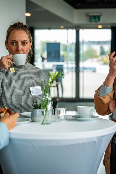 Kaffeepause im Foyer, 3 Personen trinken Kaffee am Stehtisch